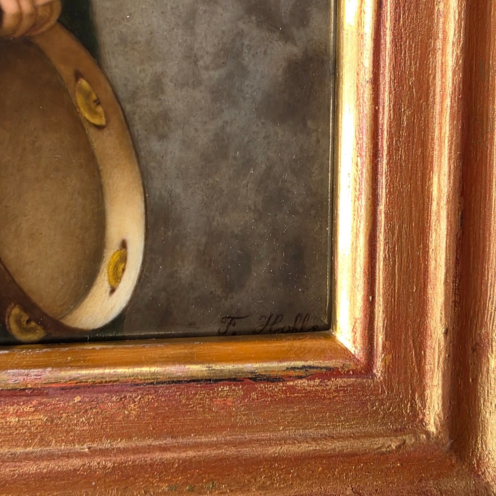 A rectangular hand-painted porcelain plaque depicting a young woman with a tambourine, set within a thick moulded gilt frame. View XI