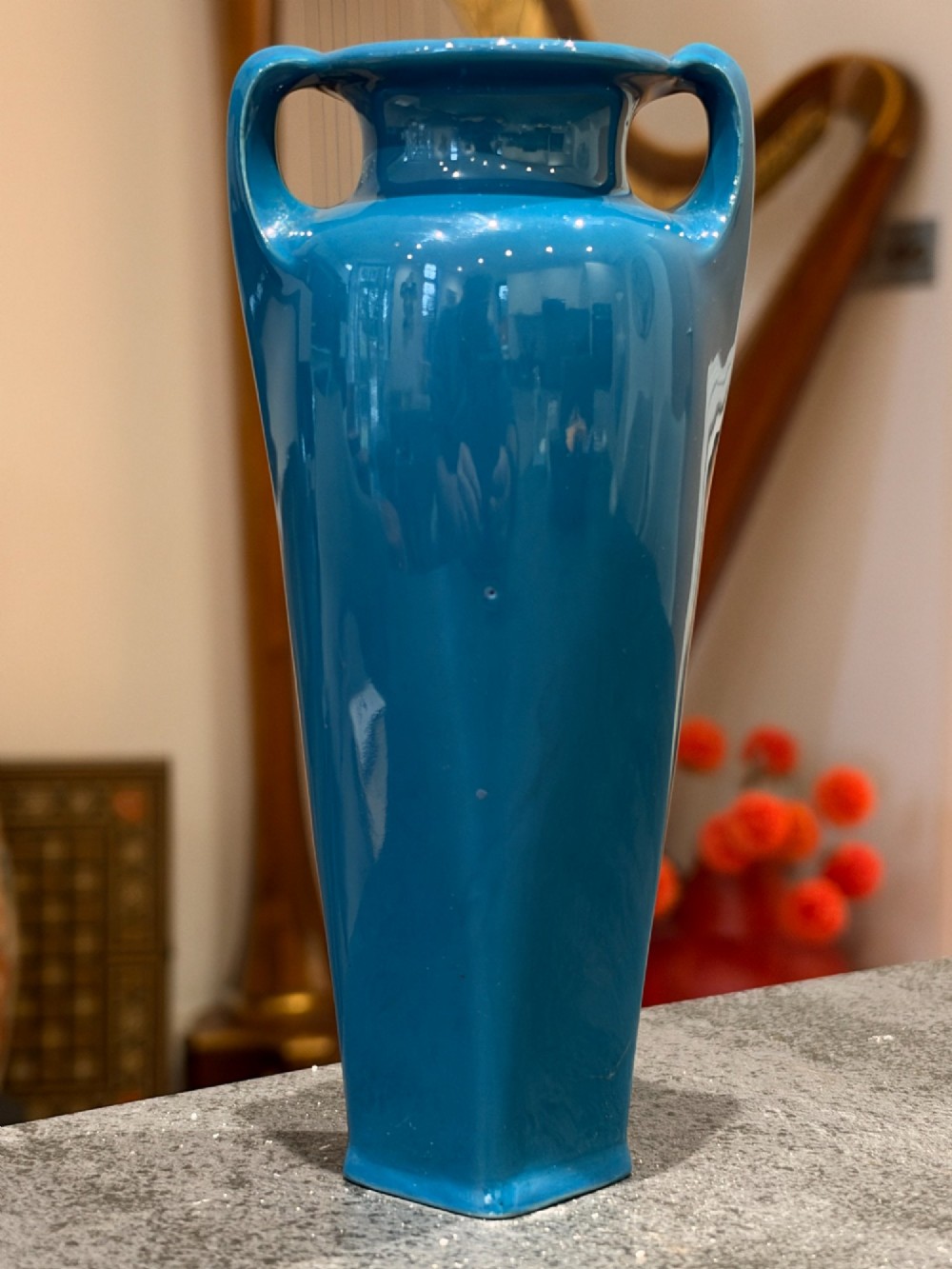 A tapered teal blue porcelain vase featuring twin loop handles and white pate-sur-pate floral relief decoration. View VII