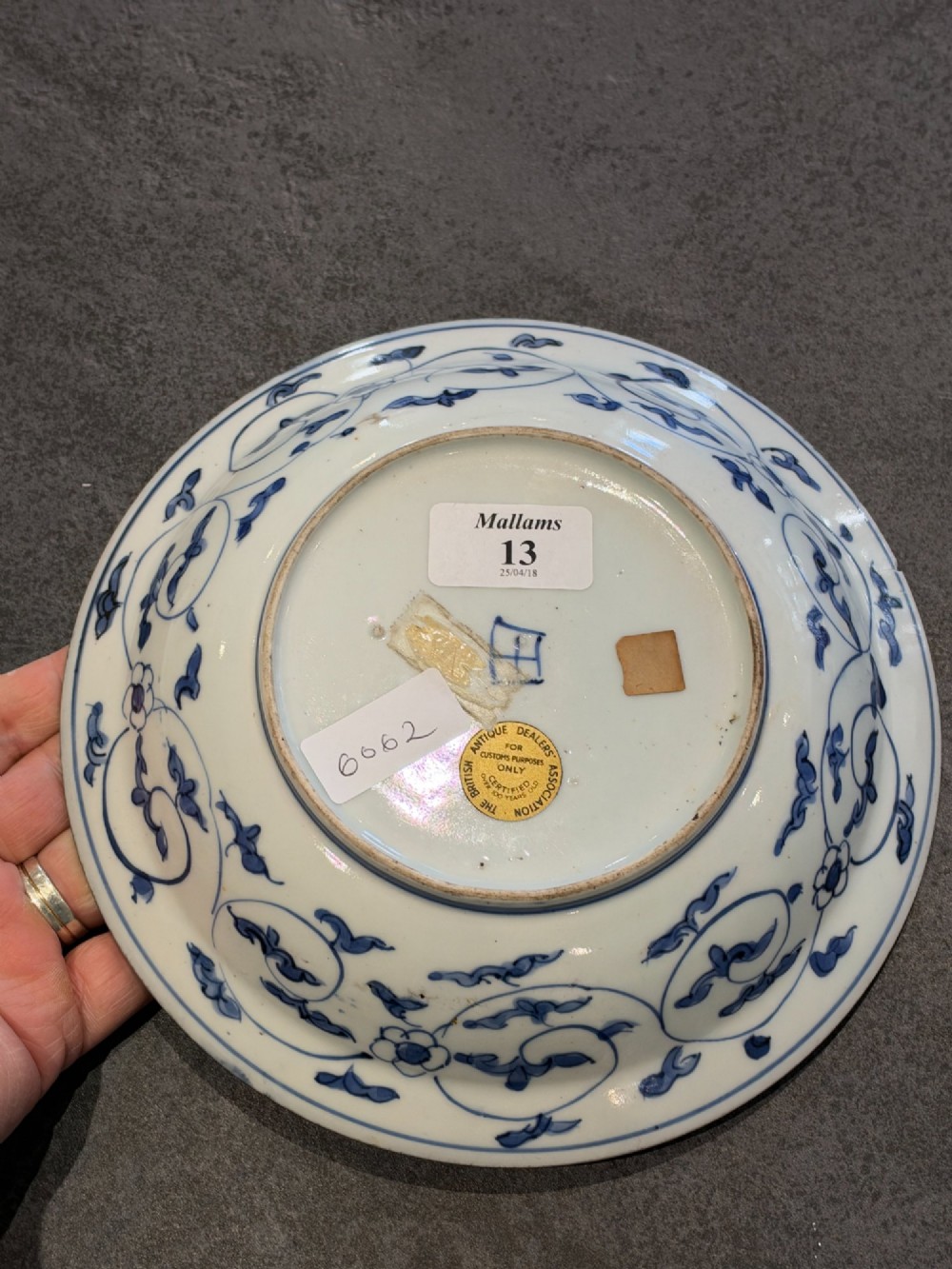 A circular 17th-century Chinese Kraak porcelain dish featuring underglaze cobalt blue panelled decoration surrounding a central landscape reserve. View III