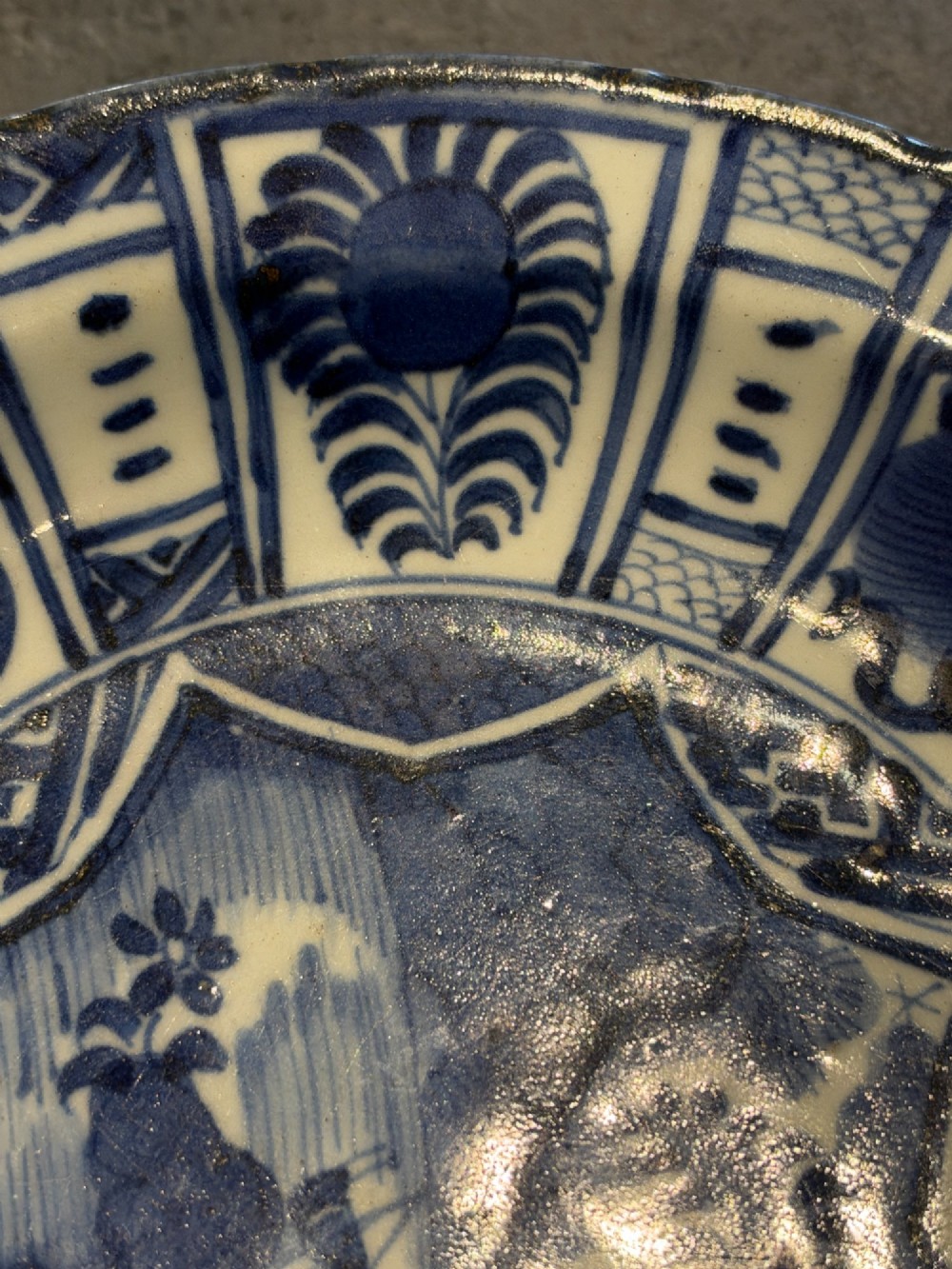 A circular 17th-century Chinese Kraak porcelain dish featuring underglaze cobalt blue panelled decoration surrounding a central landscape reserve. View VIII