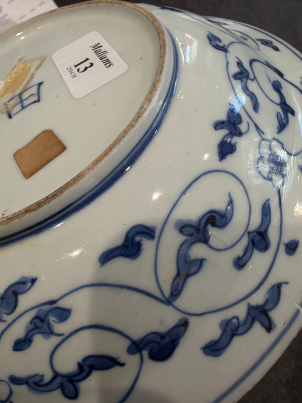 A circular 17th-century Chinese Kraak porcelain dish featuring underglaze cobalt blue panelled decoration surrounding a central landscape reserve. View X