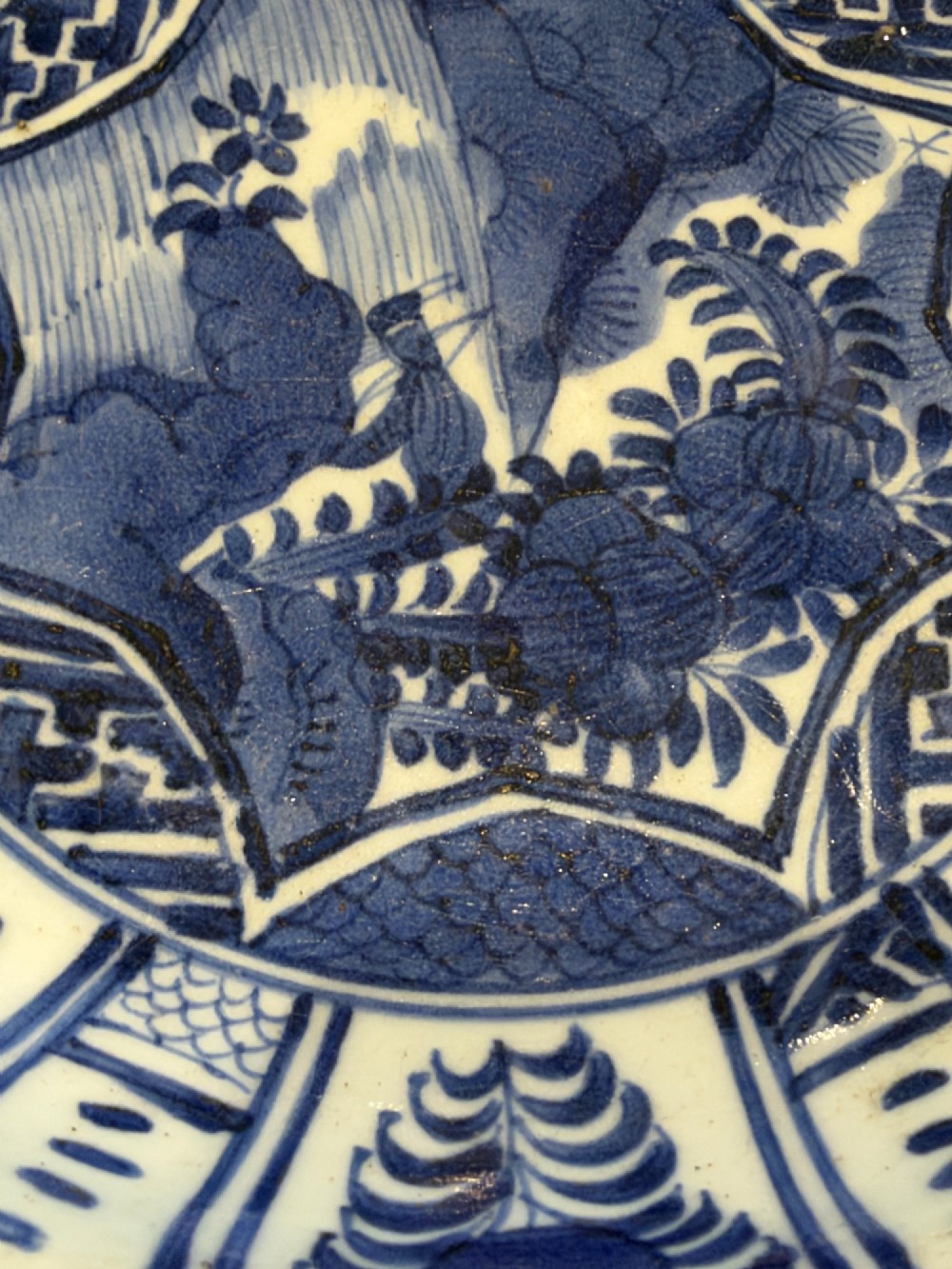 A circular 17th-century Chinese Kraak porcelain dish featuring underglaze cobalt blue panelled decoration surrounding a central landscape reserve. View XIII
