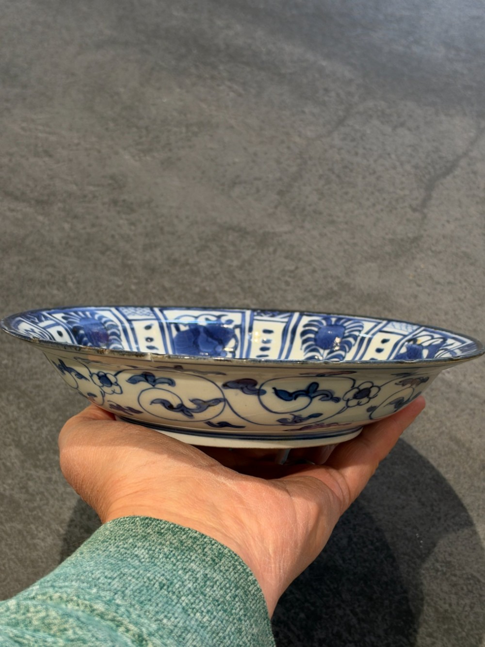 A circular 17th-century Chinese Kraak porcelain dish featuring underglaze cobalt blue panelled decoration surrounding a central landscape reserve. View XIV