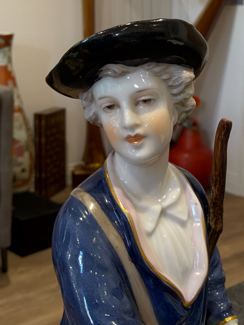 A pair of antique hand-painted German porcelain figures depicting a shepherdess with a lamb and a shepherd holding a basket, set on circular gilded bases. View III