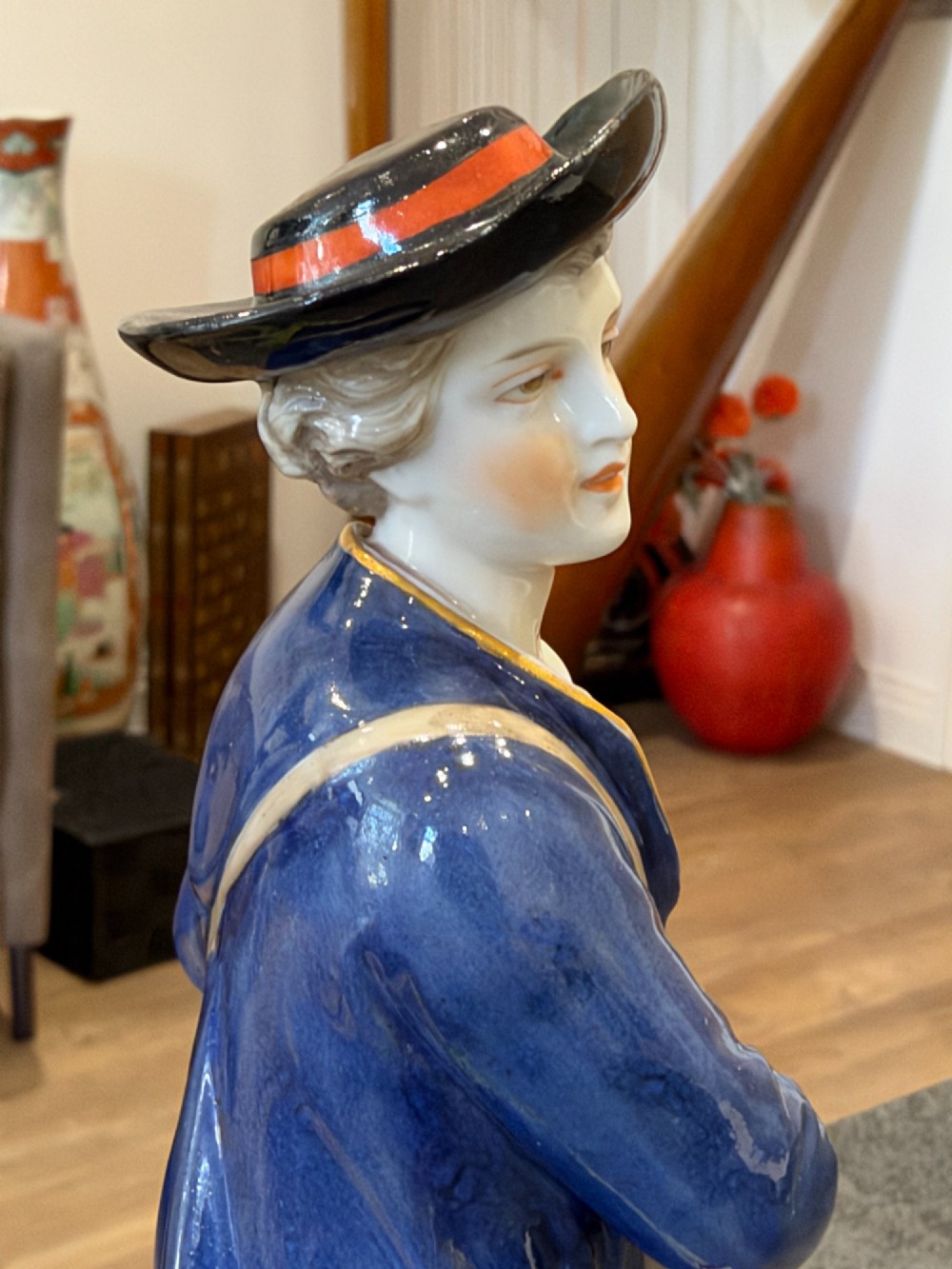 A pair of antique hand-painted German porcelain figures depicting a shepherdess with a lamb and a shepherd holding a basket, set on circular gilded bases. View VII