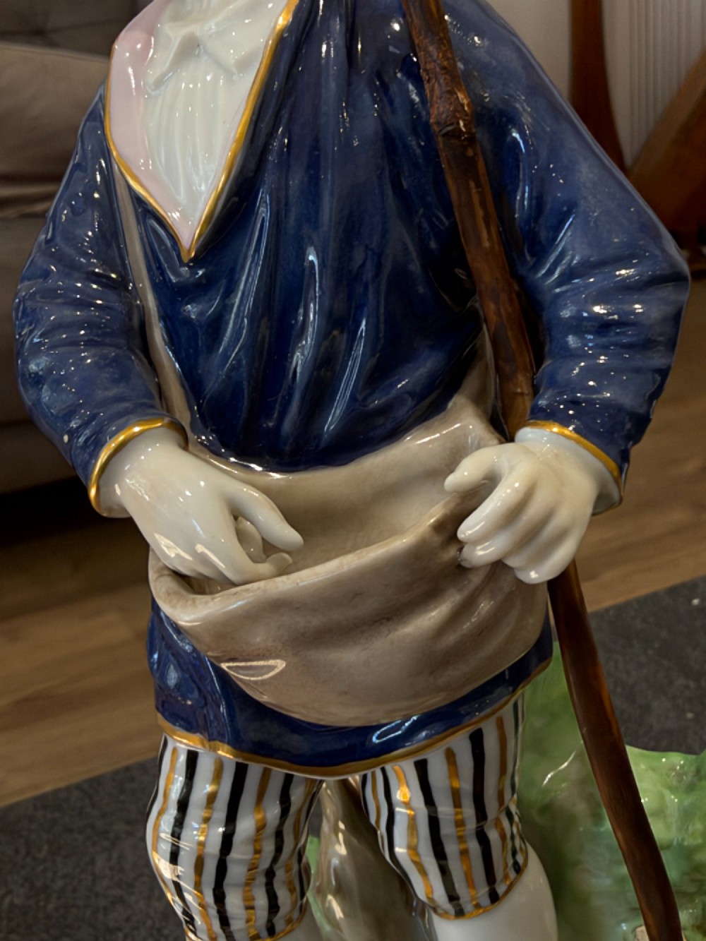 A pair of antique hand-painted German porcelain figures depicting a shepherdess with a lamb and a shepherd holding a basket, set on circular gilded bases. View XI
