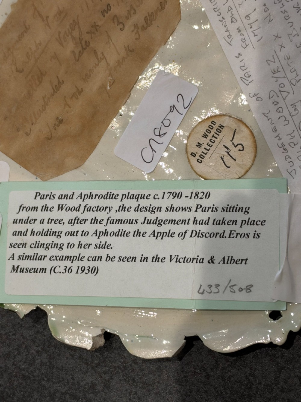 An oval cream and green lead-glazed pearlware plaque featuring relief moulding of classical figures surrounded by an ornate pierced leaf border. View VIII