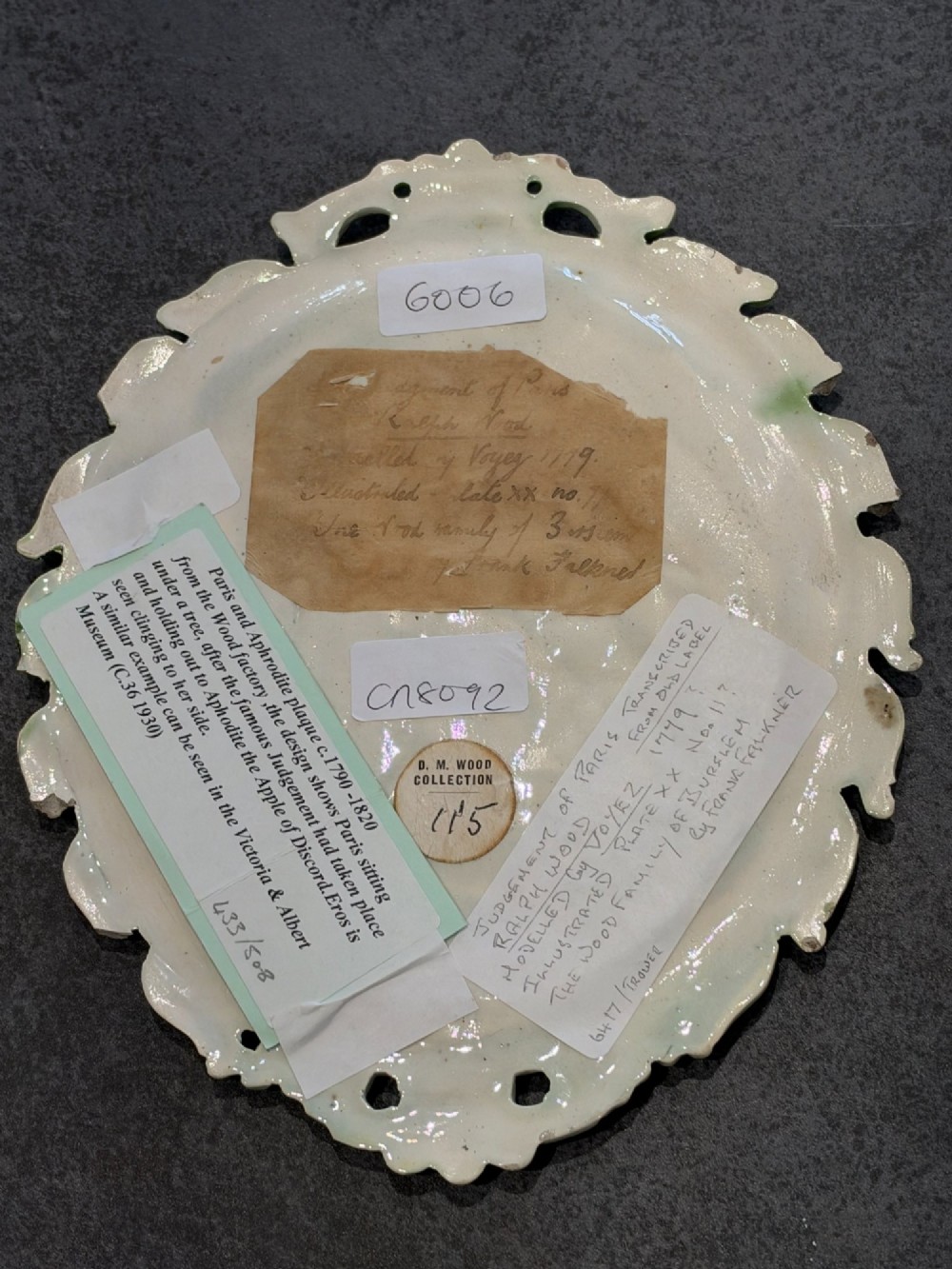 An oval cream and green lead-glazed pearlware plaque featuring relief moulding of classical figures surrounded by an ornate pierced leaf border. View IV