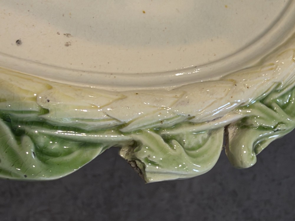 An oval cream and green lead-glazed pearlware plaque featuring relief moulding of classical figures surrounded by an ornate pierced leaf border. View XI