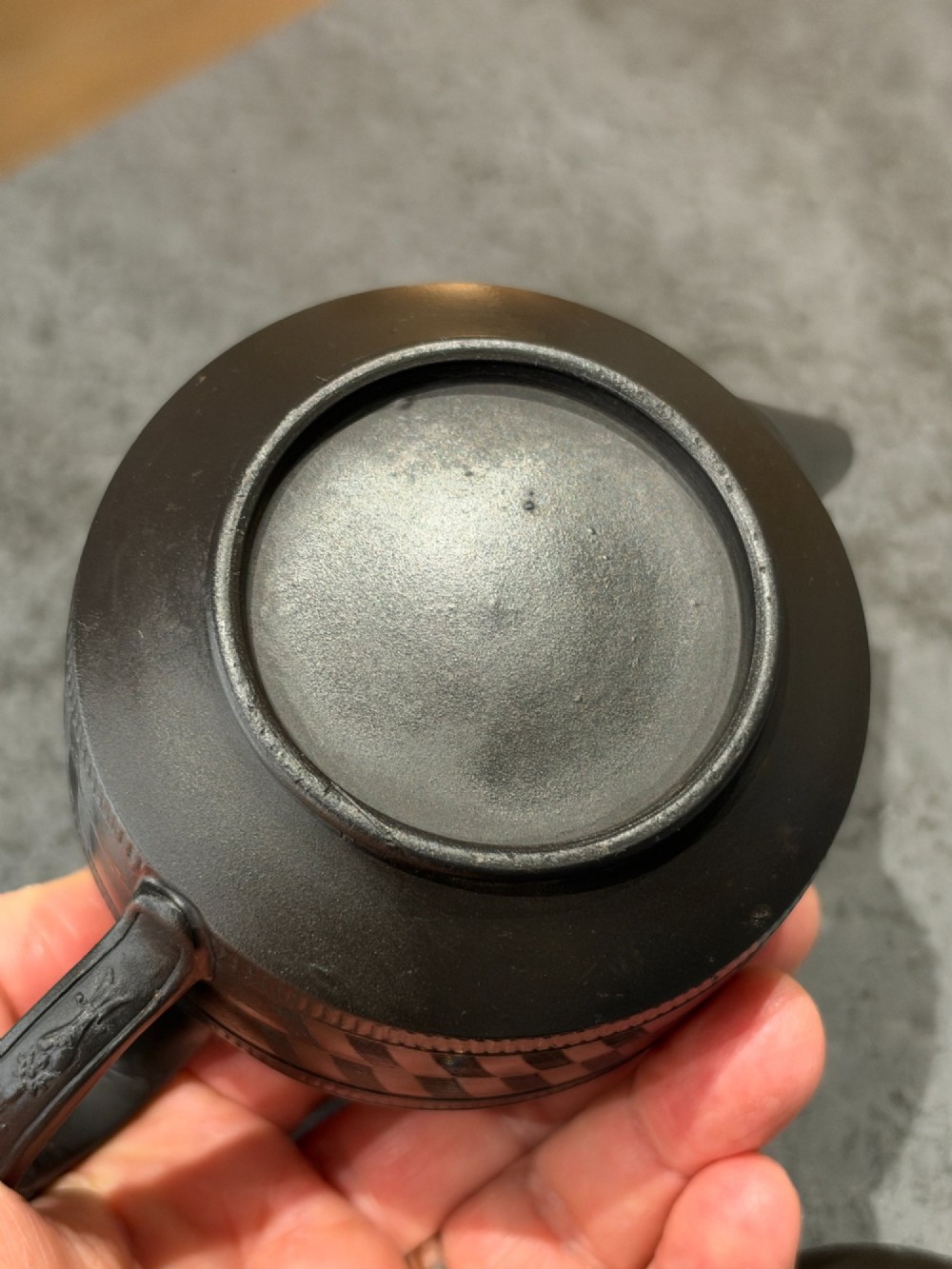 A matte black Georgian basalt stoneware teapot featuring engine-turned geometric band pattern detail and a decorative moulded handle. View V