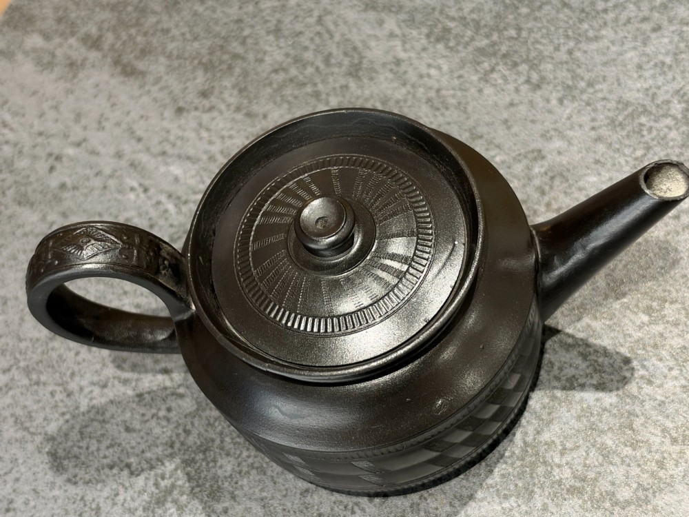 A matte black Georgian basalt stoneware teapot featuring engine-turned geometric band pattern detail and a decorative moulded handle. View VII