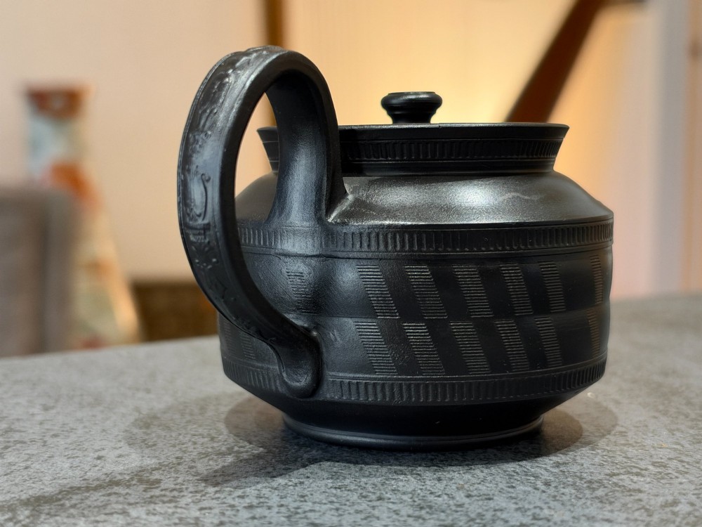 A matte black Georgian basalt stoneware teapot featuring engine-turned geometric band pattern detail and a decorative moulded handle. View XII