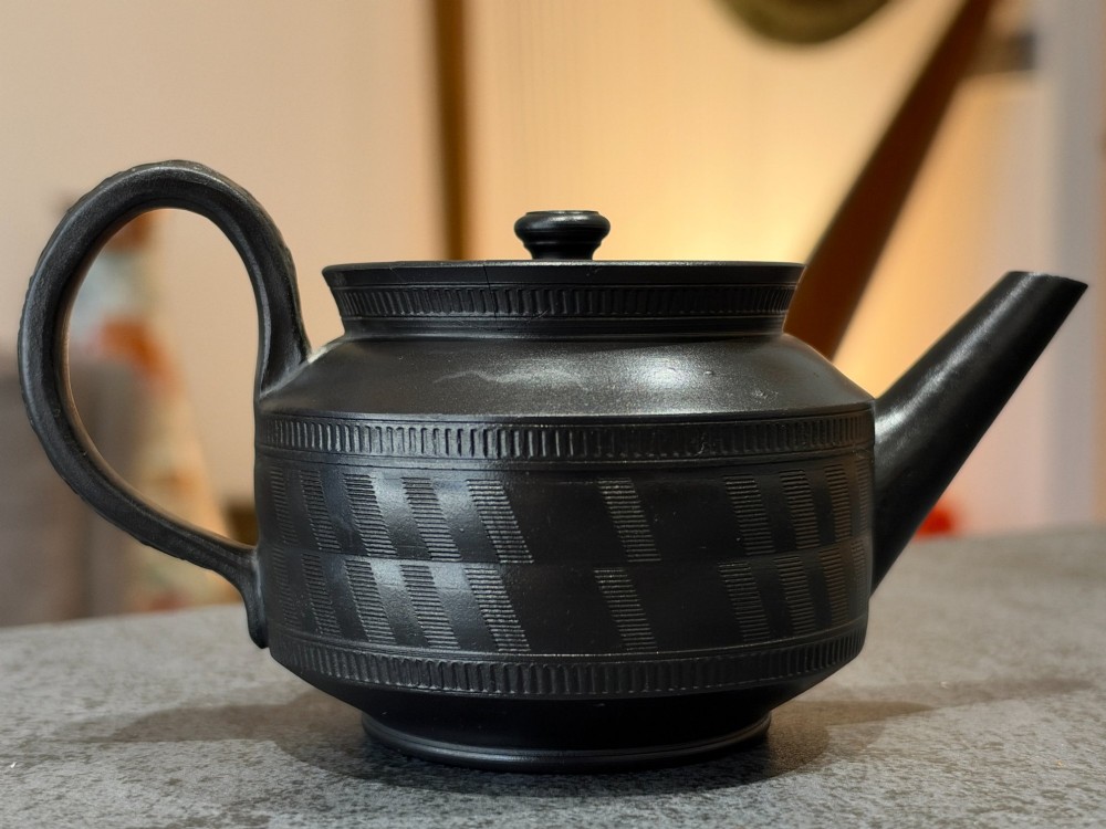 A matte black Georgian basalt stoneware teapot featuring engine-turned geometric band pattern detail and a decorative moulded handle. View XIII