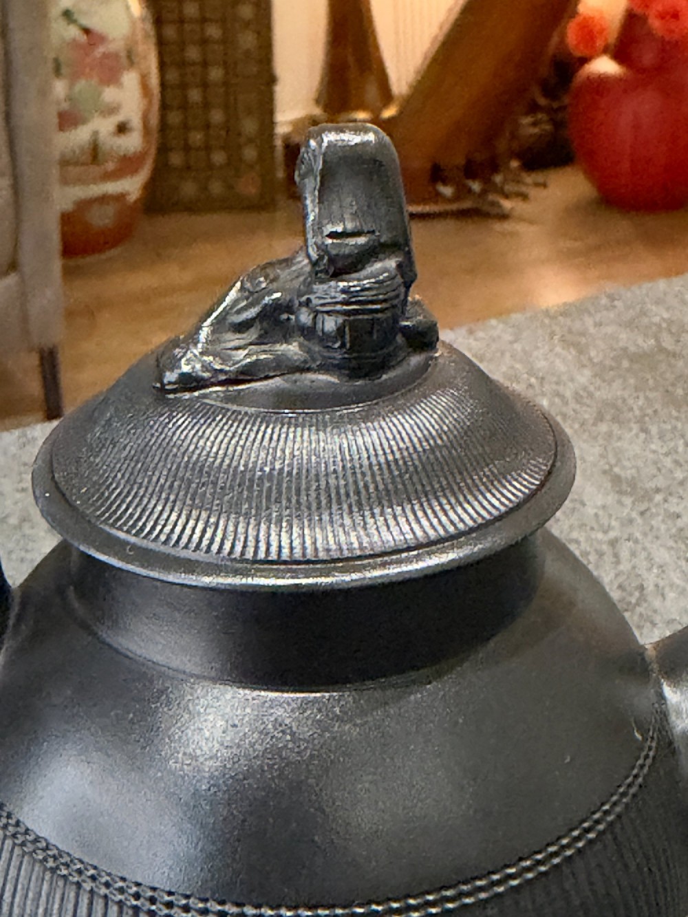 An antique matte black basalt teapot featuring an engine-turned ribbed body, a fitted lid with a figural knop, and a curved handle. View VI