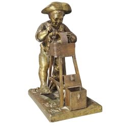 CHARLESLOUIS MENNE SWEDISH 18221894 A GILT BRONZE MATCH HOLDER STRIKER CAST AS A BOY SHARPENING A KNIFE UPON A GRINDING WHEEL
