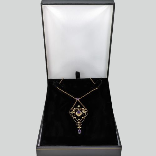 fig 4. An Edwardian 9ct gold openwork lavalier pendant set with oval and pear-cut amethysts and seed pearls on a chain.