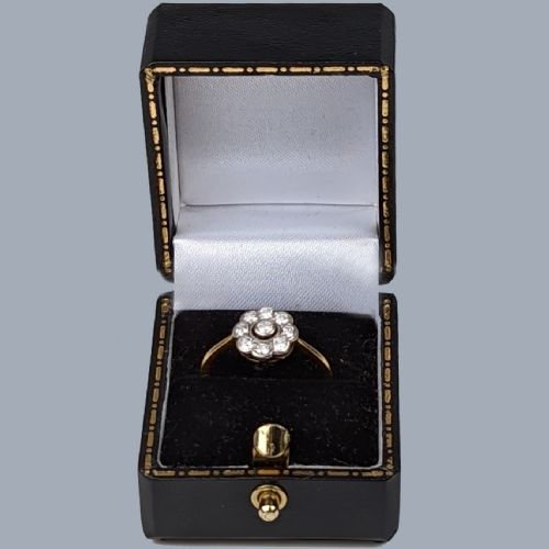 fig 5. An Edwardian cluster ring in 18ct yellow gold and platinum featuring a central diamond surrounded by a floral halo of smaller diamonds.