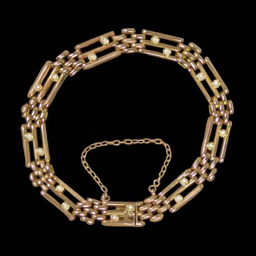 fig 3. A circular Victorian 15ct yellow gold gate link bracelet set with split pearls and featuring a safety chain.