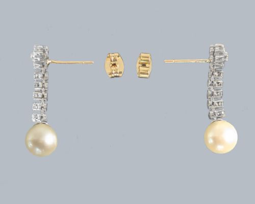 fig 3. A pair of 1960s 18ct white gold drop earrings featuring floral diamond cluster tops above linear diamond links and round white pearls.