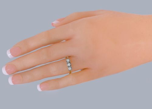 fig 1. A three-stone round diamond trilogy ring set in white metal claw mounts on an 18ct yellow gold band.