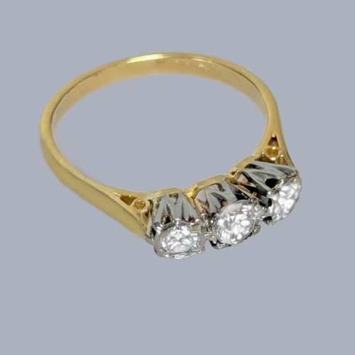 fig 4. A three-stone round diamond trilogy ring set in white metal claw mounts on an 18ct yellow gold band.