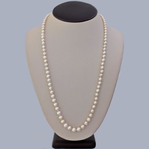 fig 1. A long single strand of graduated white cultured pearls featuring an 18ct gold clasp with a dark accent pearl and safety chain.