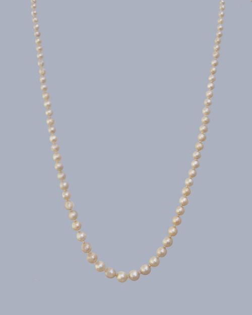 fig 4. A long single strand of graduated white cultured pearls featuring an 18ct gold clasp with a dark accent pearl and safety chain.