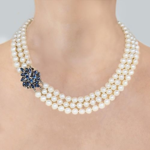 fig 1. A vintage three-strand white pearl necklace joined by a silver floral clasp set with marquise-cut blue sapphires and small diamonds.