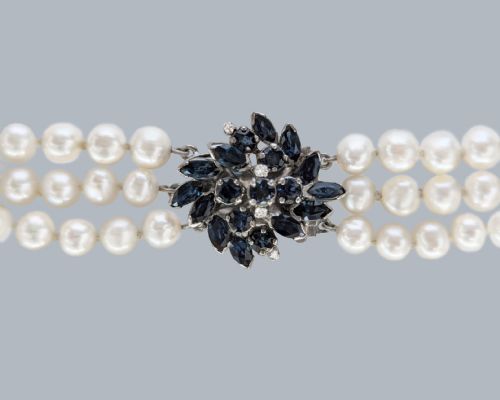 fig 3. A vintage three-strand white pearl necklace joined by a silver floral clasp set with marquise-cut blue sapphires and small diamonds.