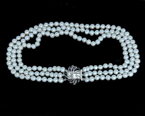 fig 5. A vintage three-strand white pearl necklace joined by a silver floral clasp set with marquise-cut blue sapphires and small diamonds.
