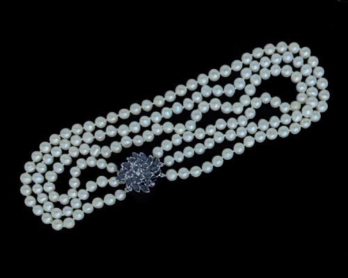 fig 7. A vintage three-strand white pearl necklace joined by a silver floral clasp set with marquise-cut blue sapphires and small diamonds.