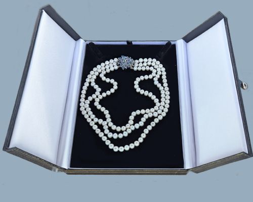 fig 8. A vintage three-strand white pearl necklace joined by a silver floral clasp set with marquise-cut blue sapphires and small diamonds.