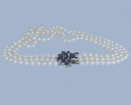 fig 9. A vintage three-strand white pearl necklace joined by a silver floral clasp set with marquise-cut blue sapphires and small diamonds.