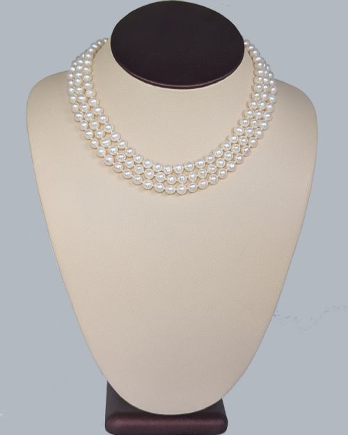 fig 10. A vintage three-strand white pearl necklace joined by a silver floral clasp set with marquise-cut blue sapphires and small diamonds.