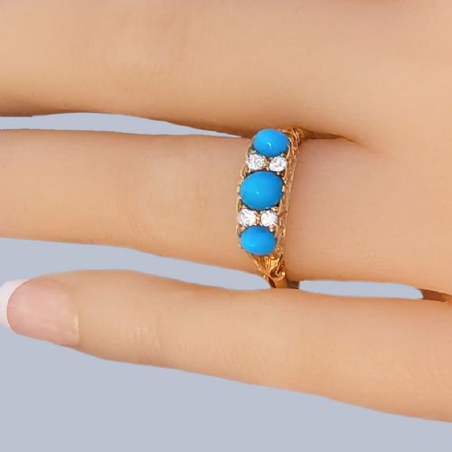fig 1. An 18ct yellow gold late Victorian ring featuring three dome-shaped blue turquoise cabochons accented by small old cut diamonds set within a carved scrollwork gallery.