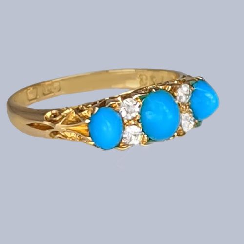 fig 2. An 18ct yellow gold late Victorian ring featuring three dome-shaped blue turquoise cabochons accented by small old cut diamonds set within a carved scrollwork gallery.