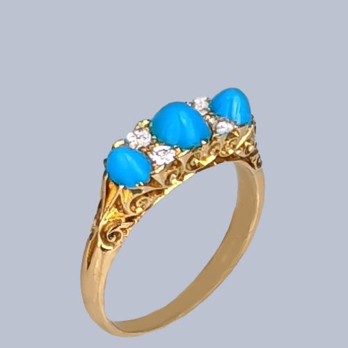fig 3. An 18ct yellow gold late Victorian ring featuring three dome-shaped blue turquoise cabochons accented by small old cut diamonds set within a carved scrollwork gallery.