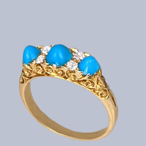 fig 4. An 18ct yellow gold late Victorian ring featuring three dome-shaped blue turquoise cabochons accented by small old cut diamonds set within a carved scrollwork gallery.