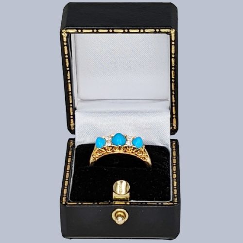 fig 6. An 18ct yellow gold late Victorian ring featuring three dome-shaped blue turquoise cabochons accented by small old cut diamonds set within a carved scrollwork gallery.
