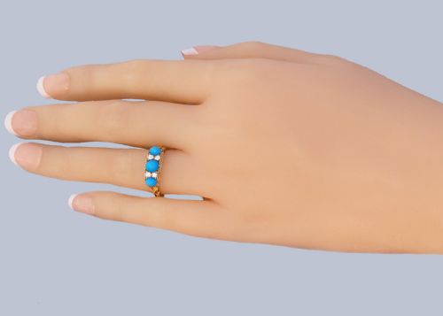 fig 7. An 18ct yellow gold late Victorian ring featuring three dome-shaped blue turquoise cabochons accented by small old cut diamonds set within a carved scrollwork gallery.