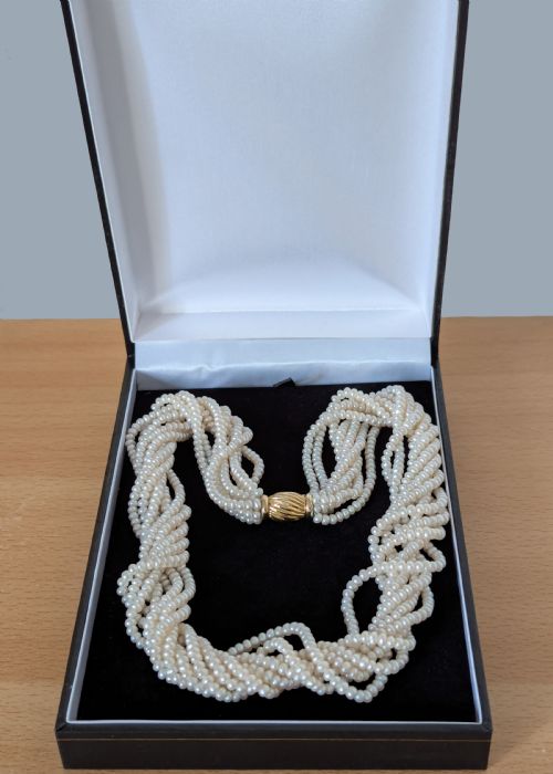 fig 6. An eight-strand freshwater seed pearl necklace with a fluted yellow gold barrel clasp.