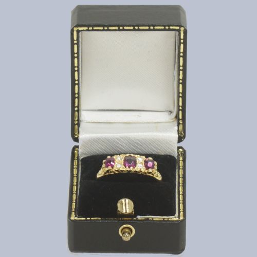 fig 5. A Late Victorian 18ct yellow gold carved gallery ring set with three oval rubies and four small old cut diamonds.