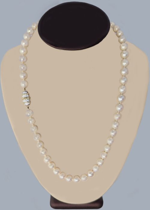 fig 1. A single strand of uniform cultured cream pearls featuring an ornate 9ct gold clasp embellished with diamonds.