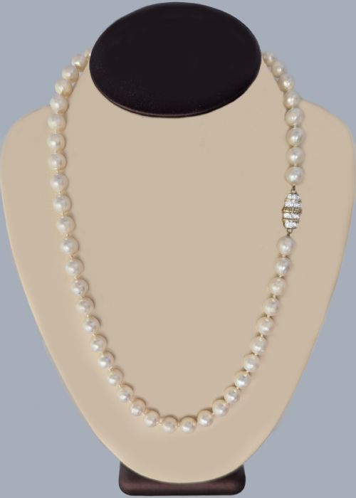 fig 3. A single strand of uniform cultured cream pearls featuring an ornate 9ct gold clasp embellished with diamonds.