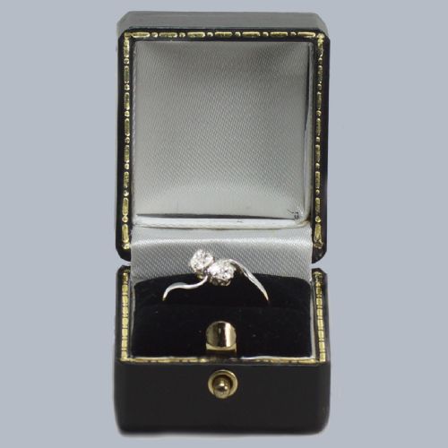 fig 4. An Edwardian two-stone crossover ring featuring two old-cut diamonds set in platinum claws on an eighteen-carat yellow gold band.