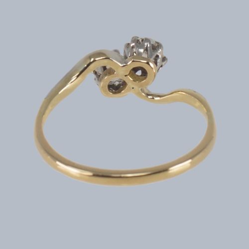 fig 6. An Edwardian two-stone crossover ring featuring two old-cut diamonds set in platinum claws on an eighteen-carat yellow gold band.