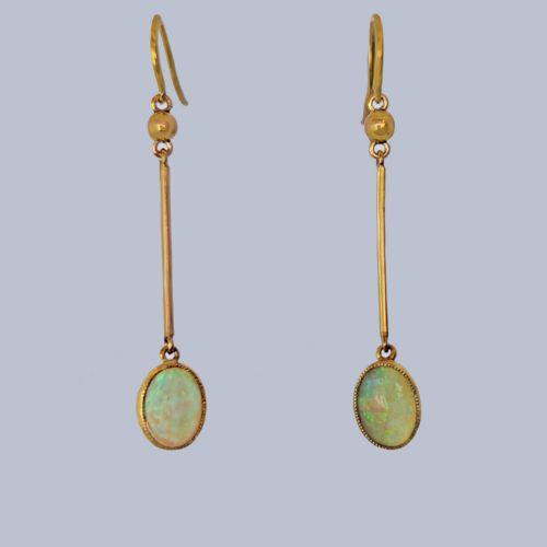 fig 2. A pair of vintage 18 carat yellow gold drop earrings featuring slender vertical bars suspended from wire hooks and terminating in oval opal cabochons displaying blue and green play-of-colour within milgrain settings.