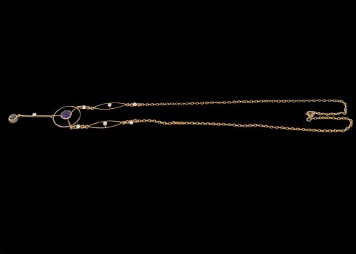fig 4. An Edwardian 18ct gold lavalier necklace featuring openwork geometric wire loops set with small diamonds, a central round bezel-set amethyst, and a vertical drop terminating in a second amethyst stone.
