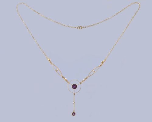 fig 6. An Edwardian 18ct gold lavalier necklace featuring openwork geometric wire loops set with small diamonds, a central round bezel-set amethyst, and a vertical drop terminating in a second amethyst stone.