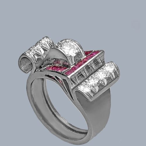 fig 4. A platinum Art Deco buckle ring featuring channel-set red rubies and pave-set old cut diamonds forming a curved scroll motif.